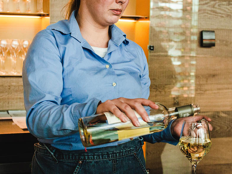 woman pouring heavy glass of wine