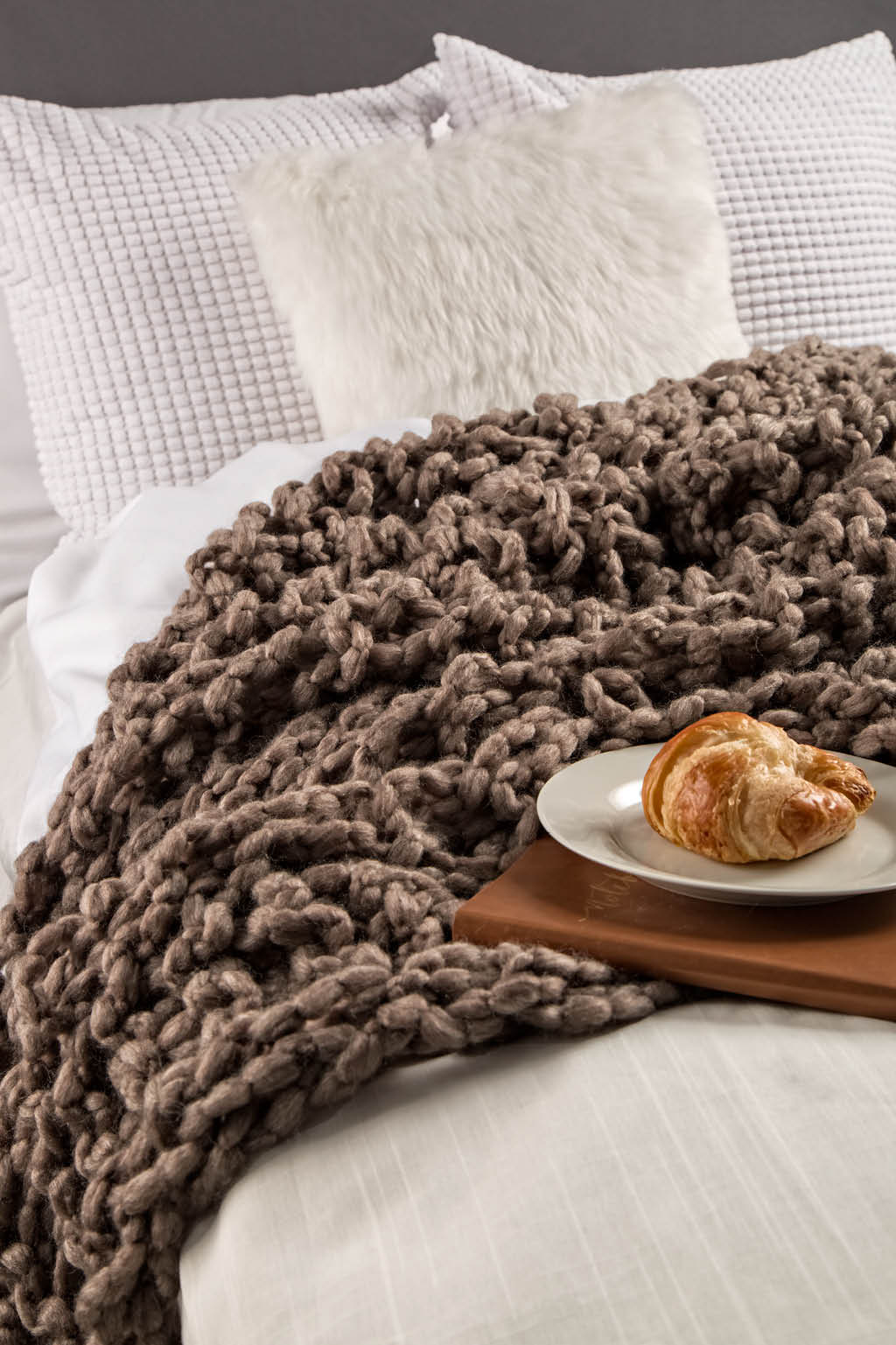 Chunky arm knit blanket on bed
