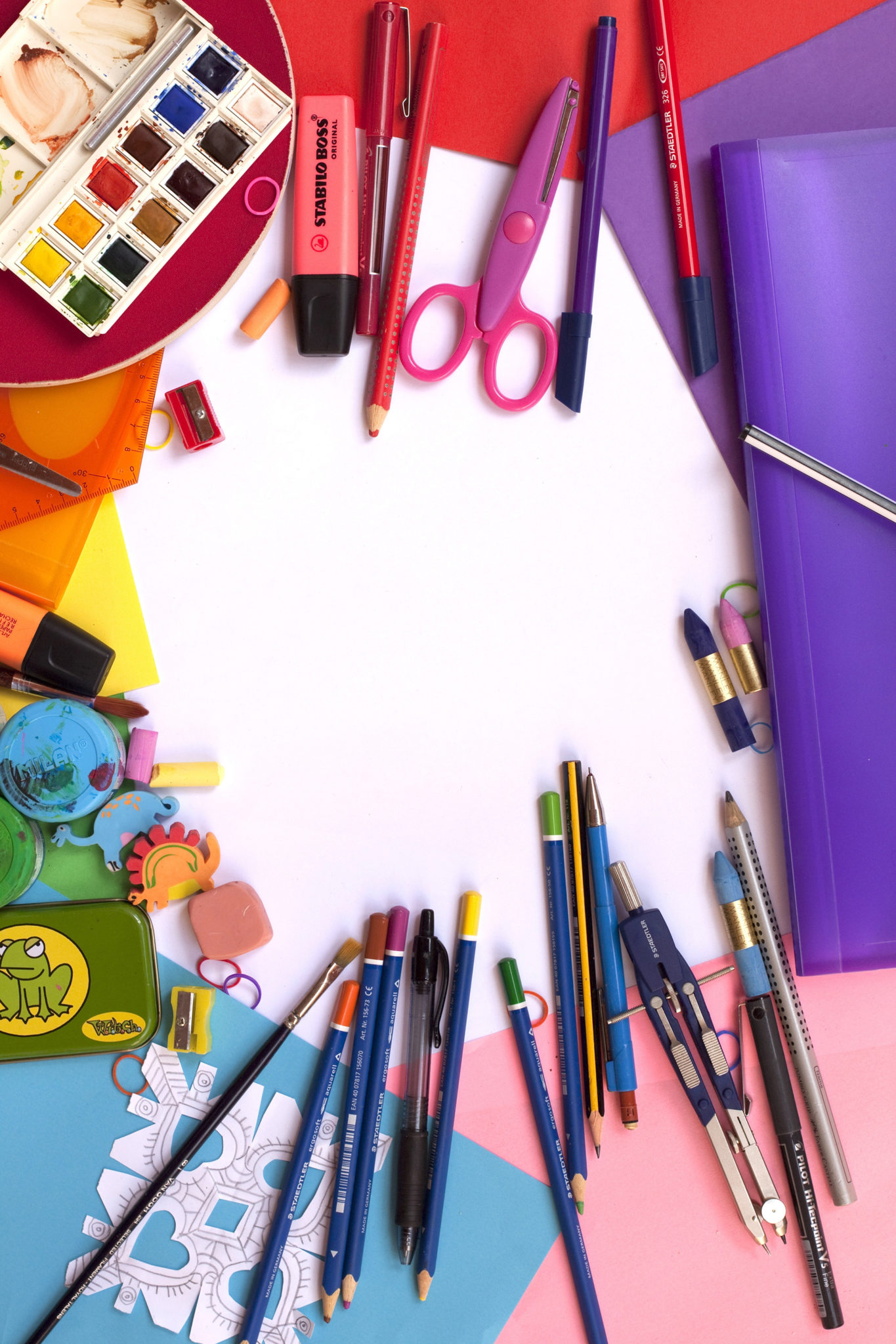 Colorful art and school supplies with colored pencils, construction paper, binder, watercolor paints, scissors, and highlighters