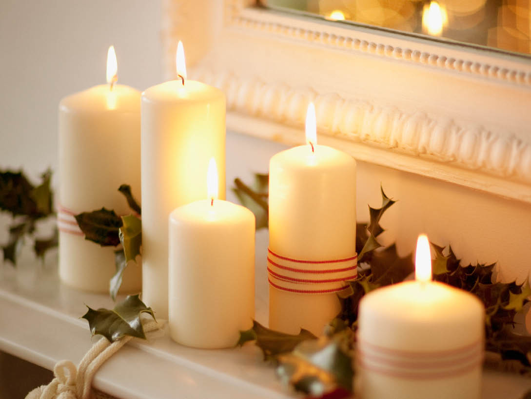 white candles lit on mantel with vines