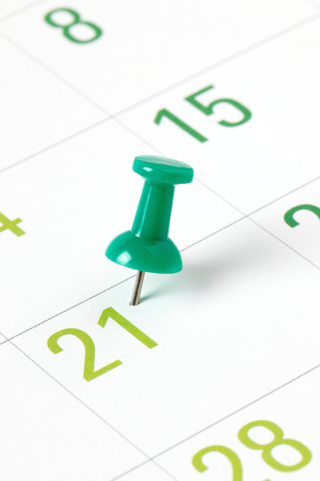 Pushpin sticking into a calendar marking a date