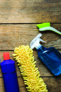 Cleaning supplies strewn across a wooden tabletop