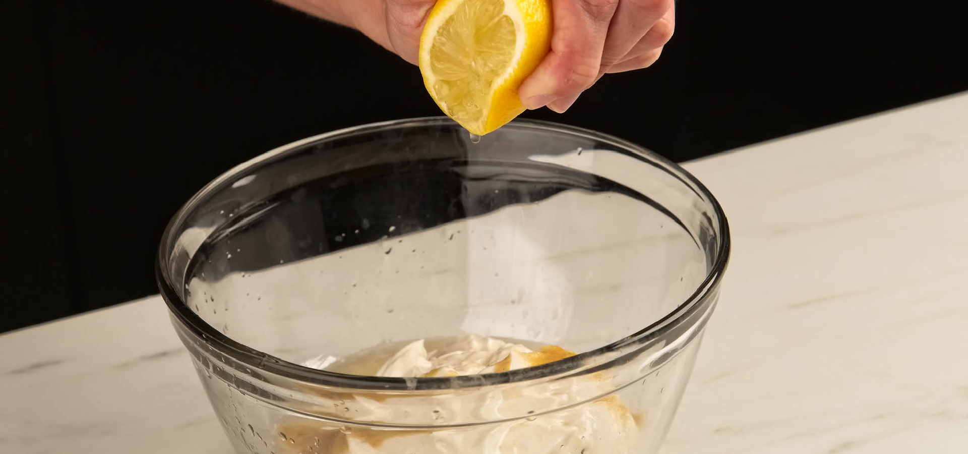 Squeezing a lemon into a bowl