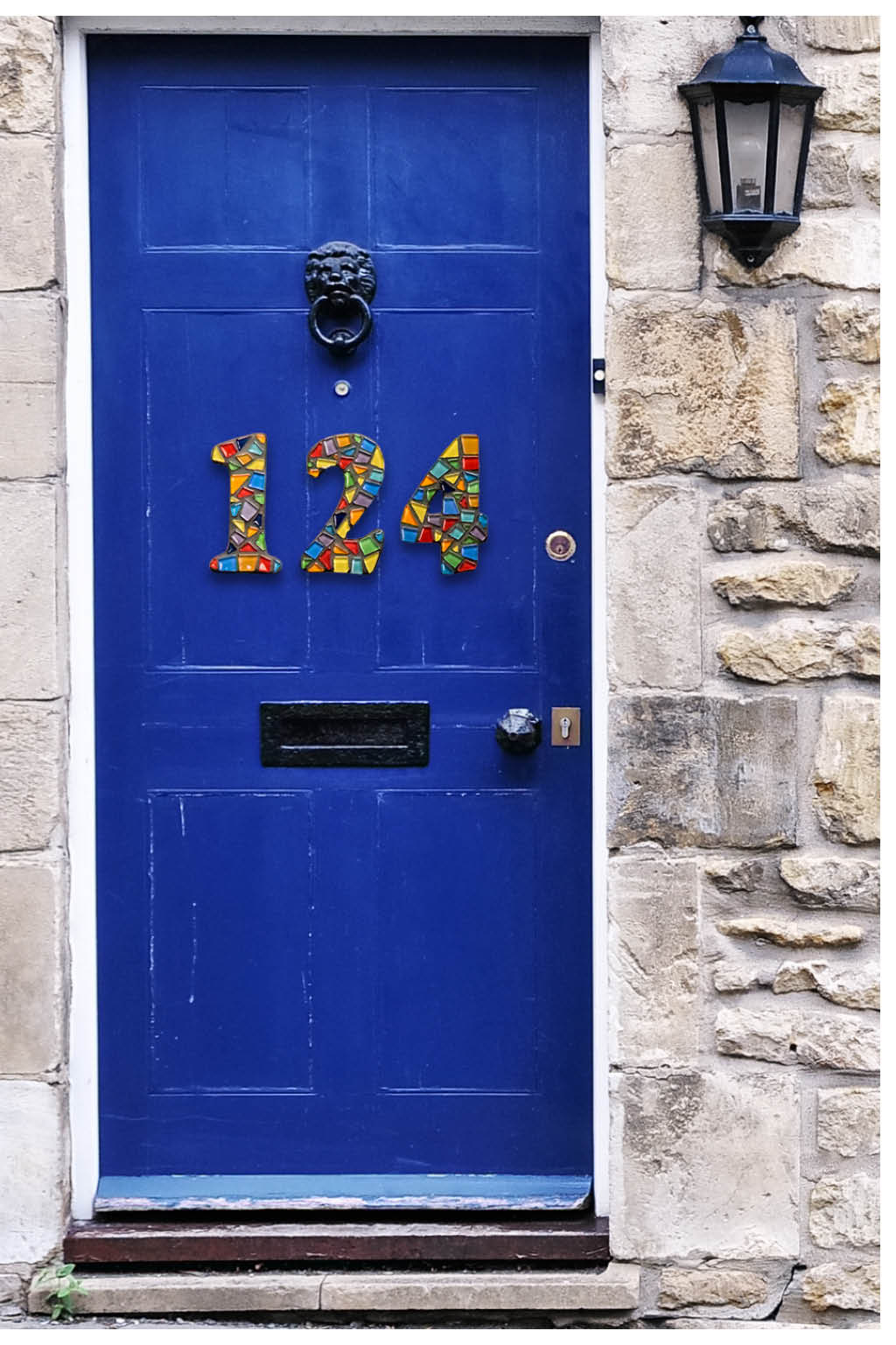 Colorful mosaic house numbers on blue door