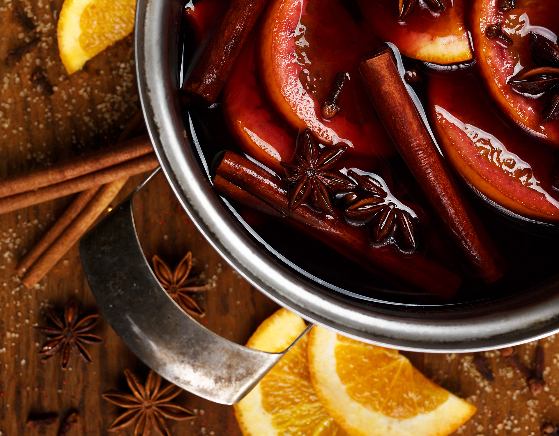 Potpourri mix of orange slices, cloves, star anise, and cinnamon sticks simmering in a pot