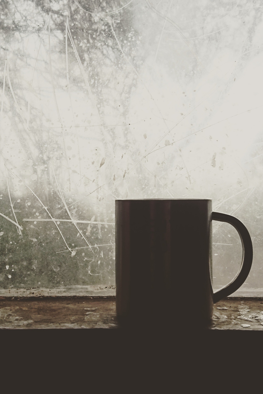 silhouette of coffee mug on windowsill