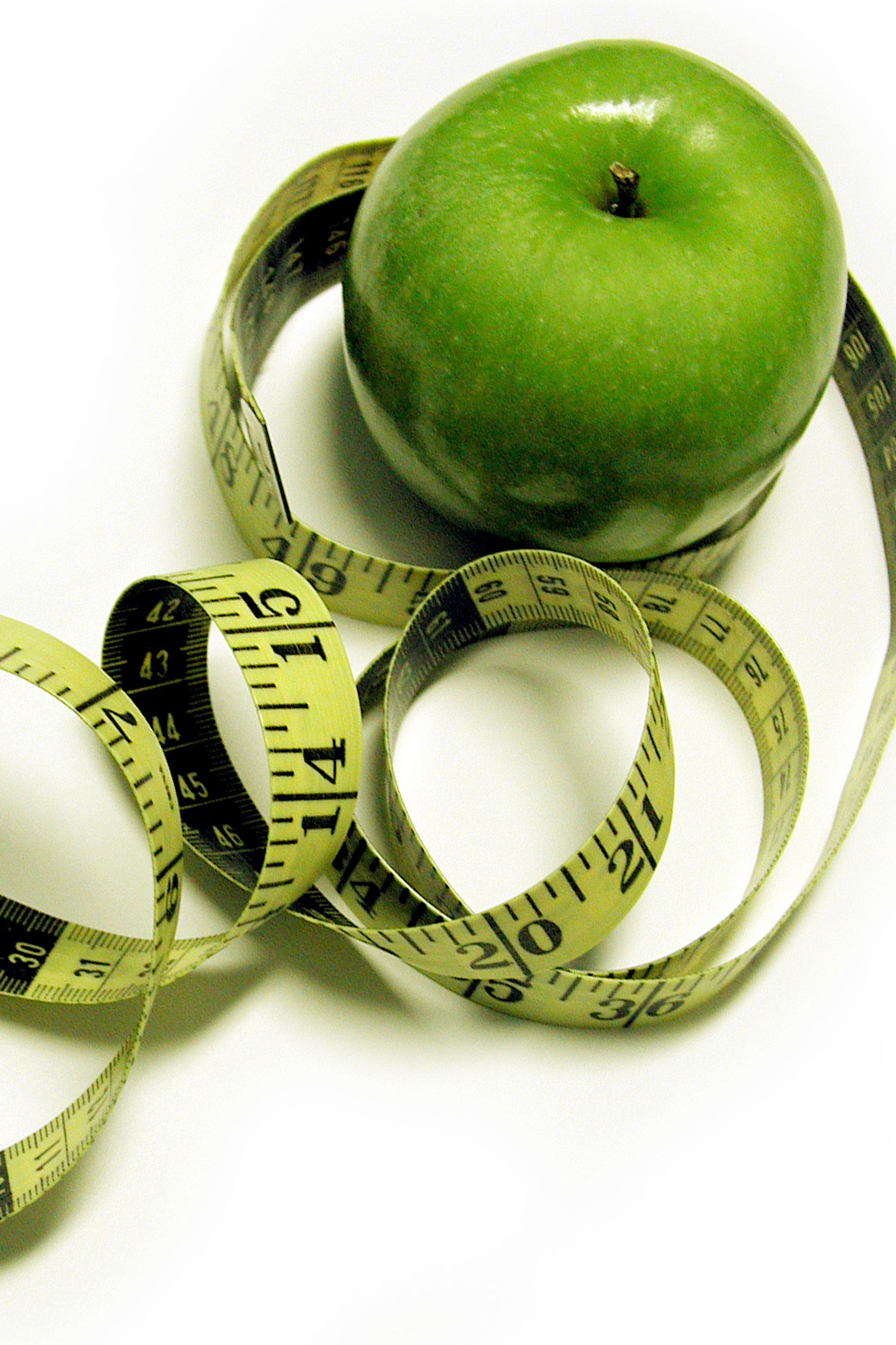 Green apple with curling tape measure