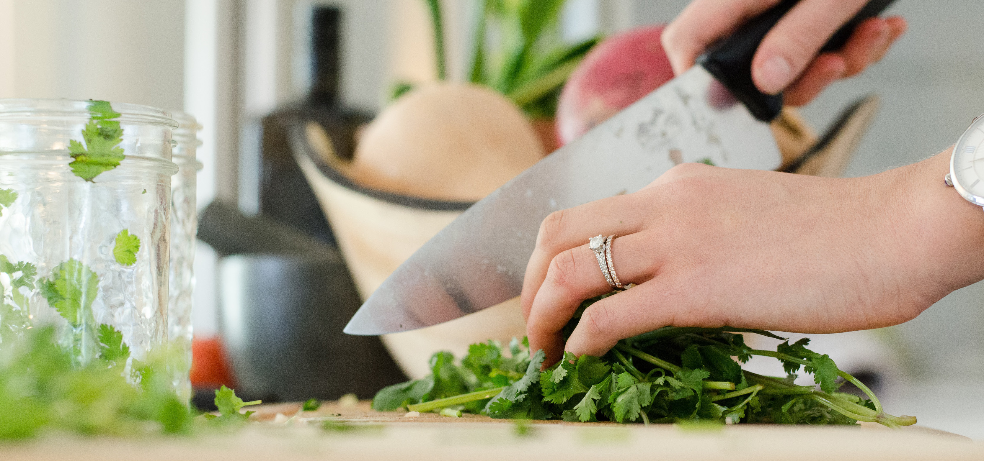 Female's hand cutting food ingredients with a butcher knife