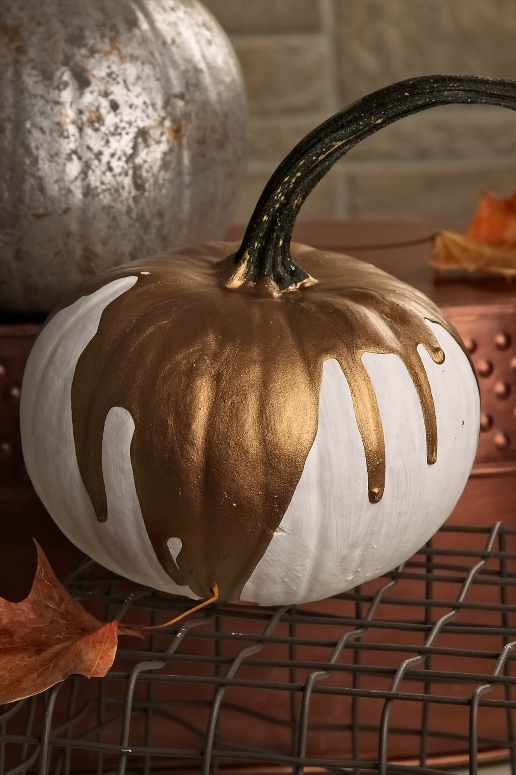 Gold drippy paint over a white pumpkin