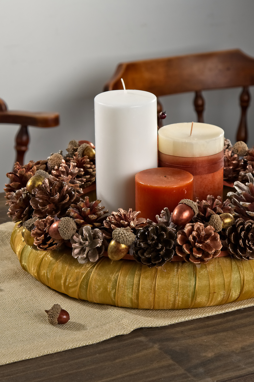 Gold pinecone wreath with candles in the center