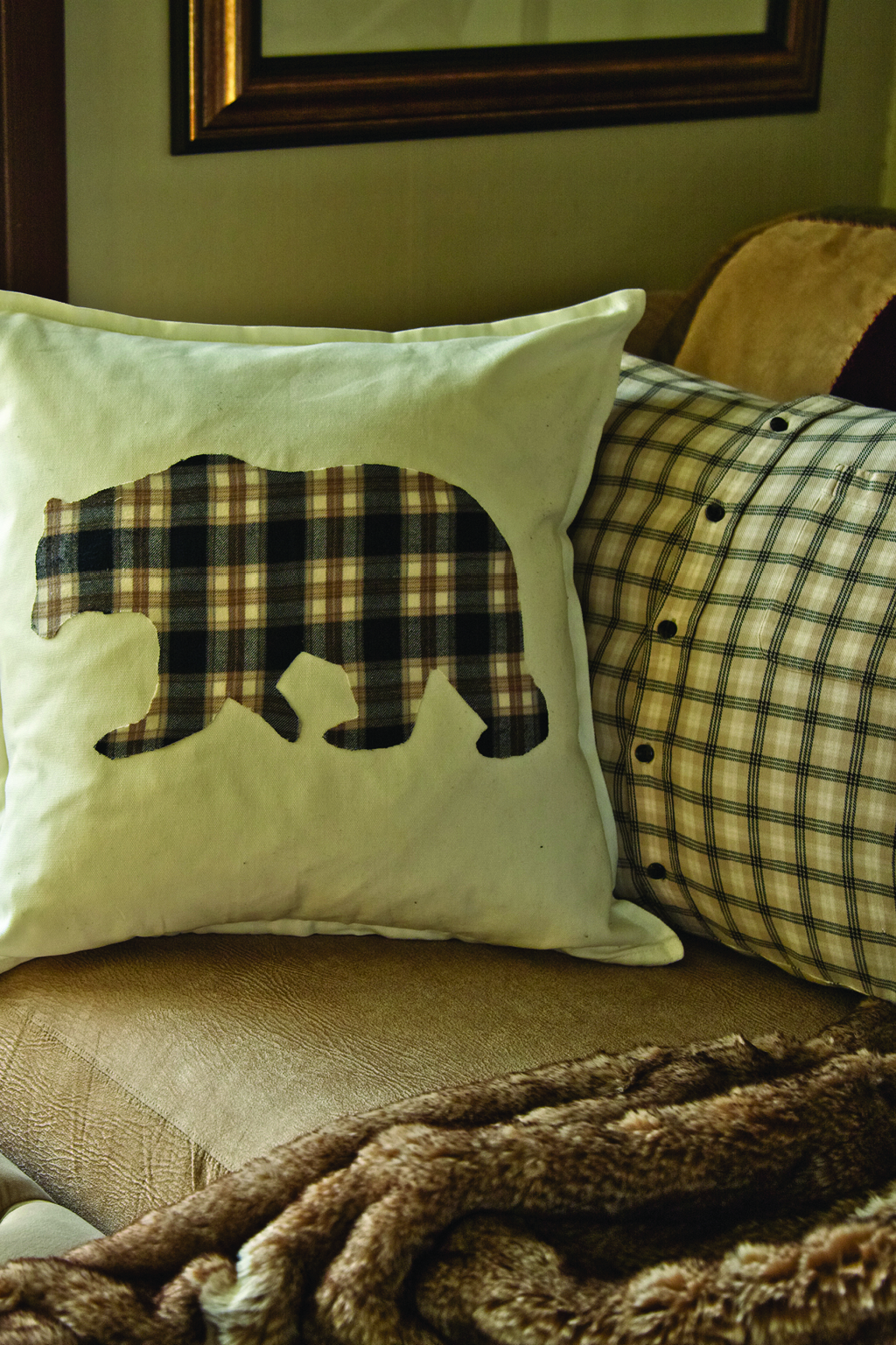 White and blue flannel pillows on a brown couch