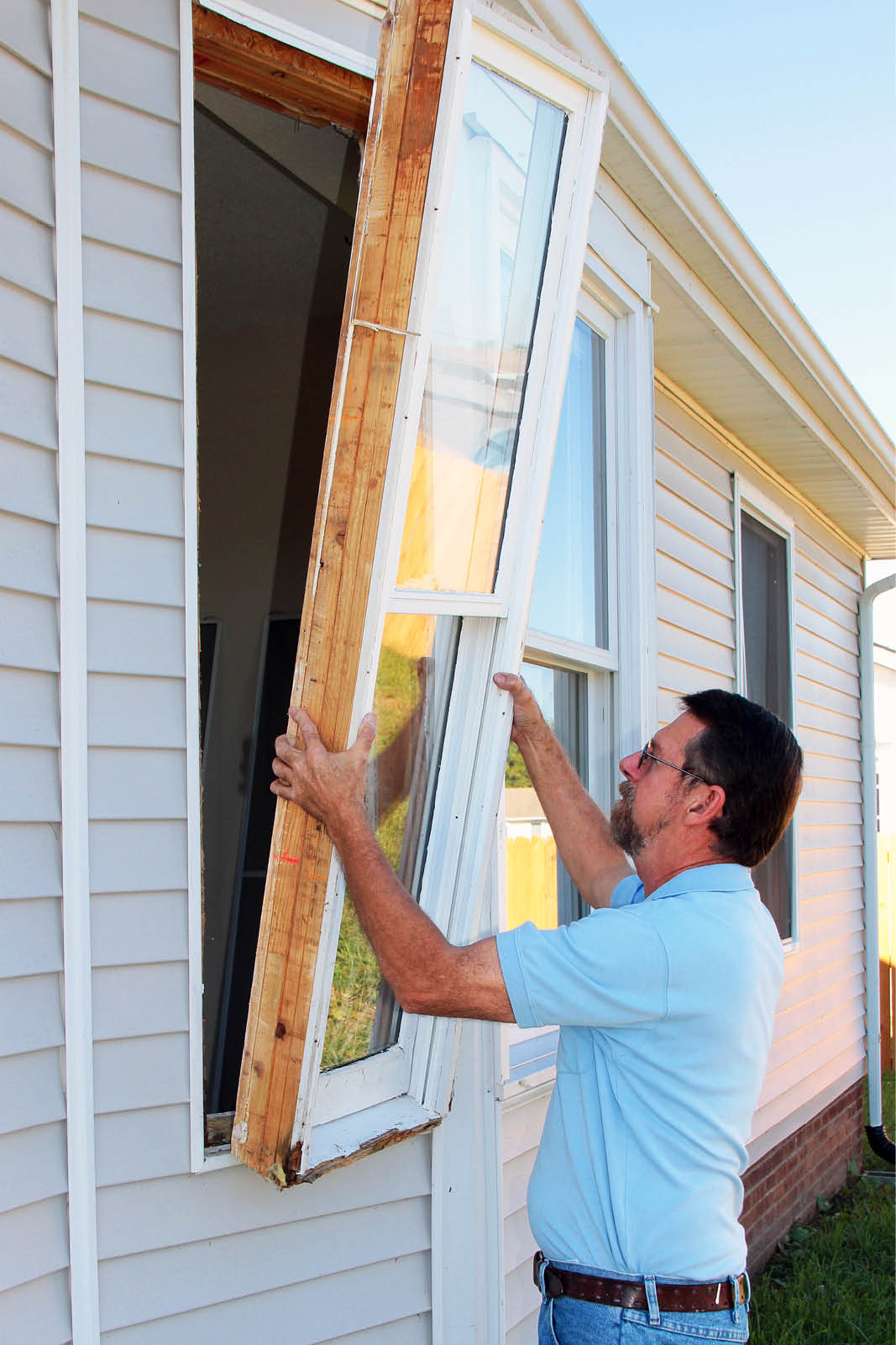 man installing window in home