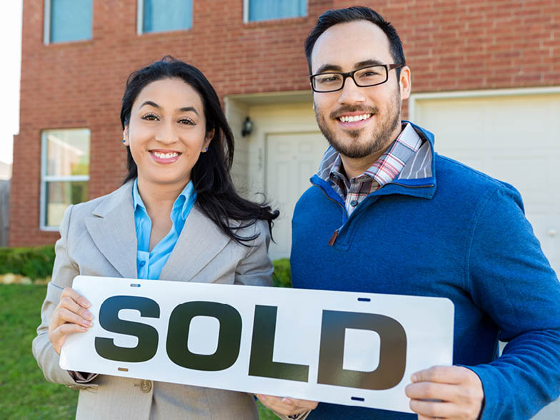 couple with sold sign