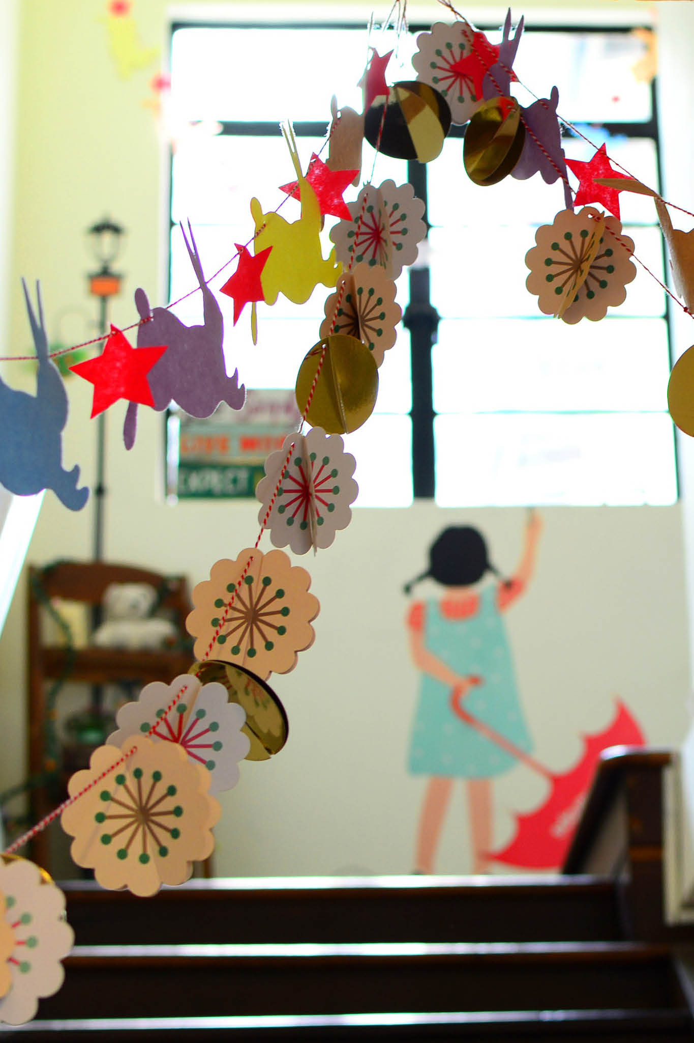 Children's artwork strung up and hanging from ceiling