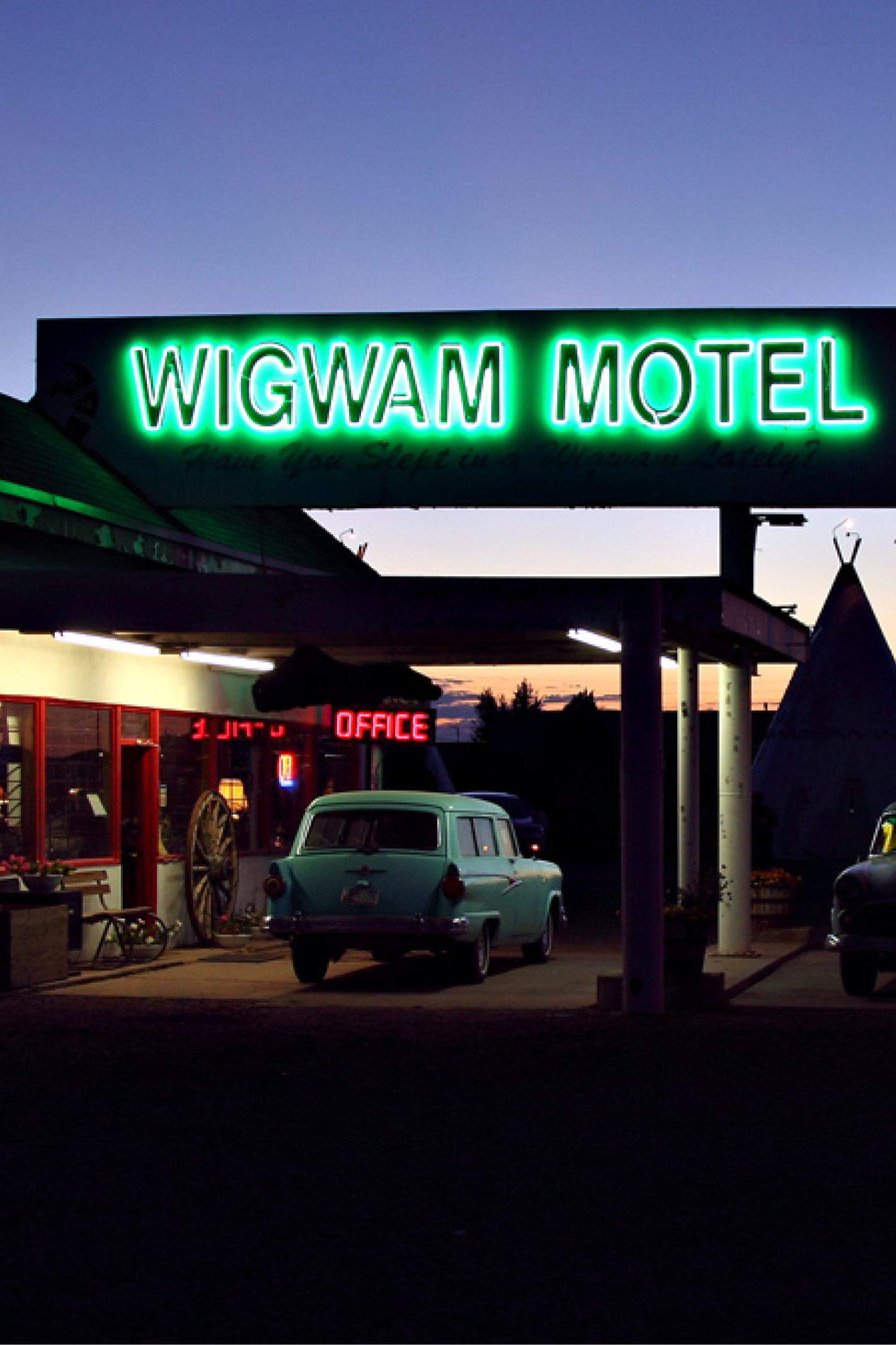 Wigwam motel with classic cars parked outside evening sky