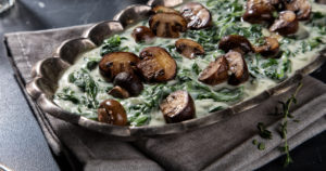 creamed spinach with mushrooms in silver dish