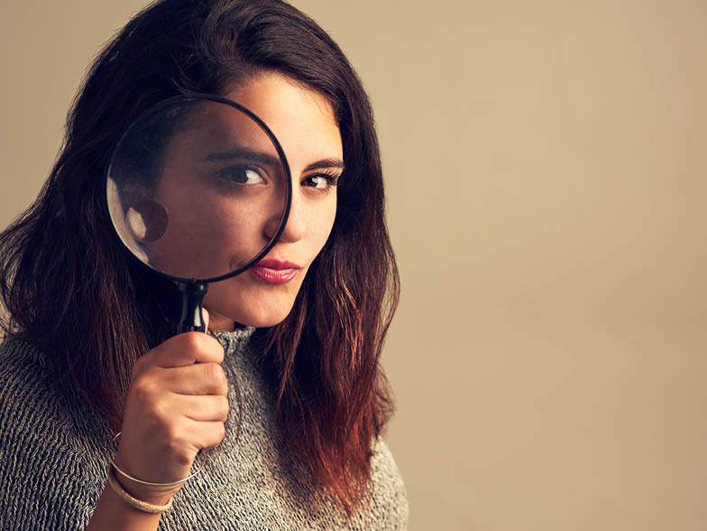 Female looking through a magnifying glass