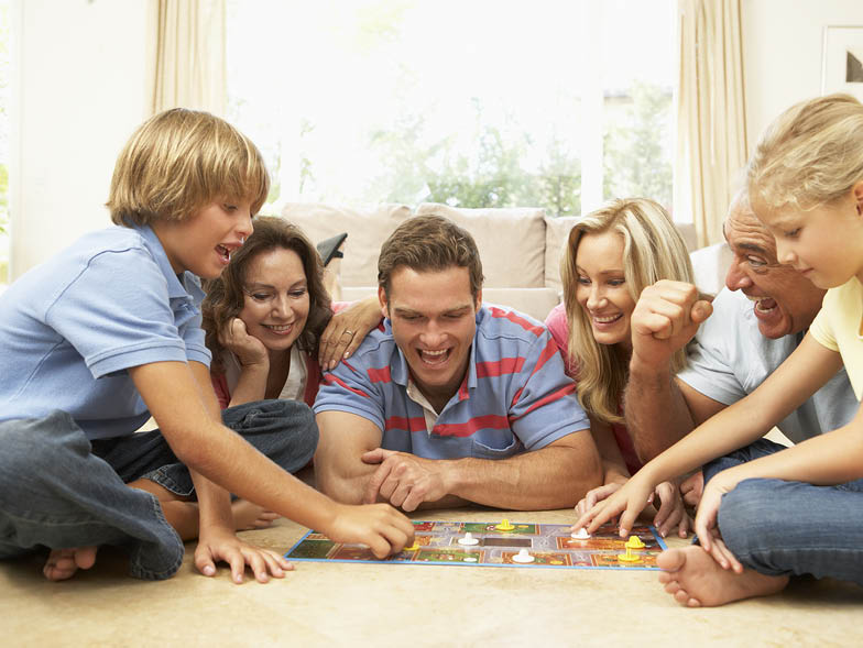 Family playing board games on living room floor