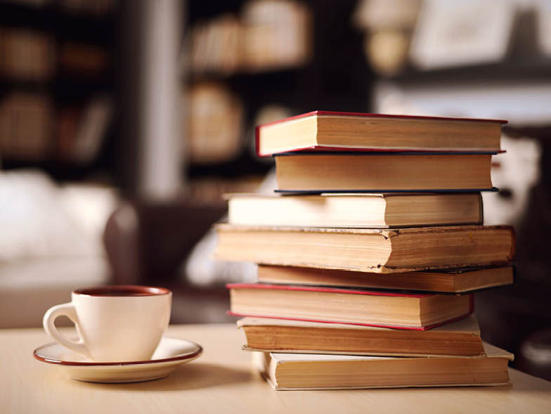 Teacup beside stack of books
