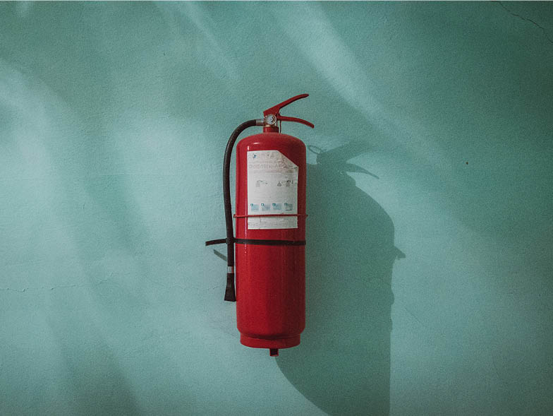Fire extinguisher against blue wall
