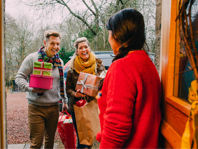 Woman greeting holiday guests at door