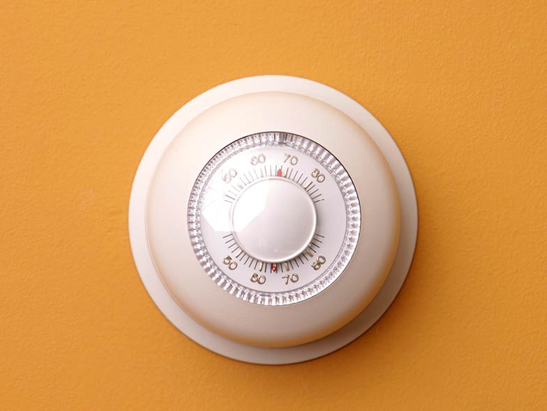 white thermostat on orange wall
