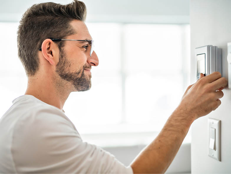Man adjusting thermostat settings