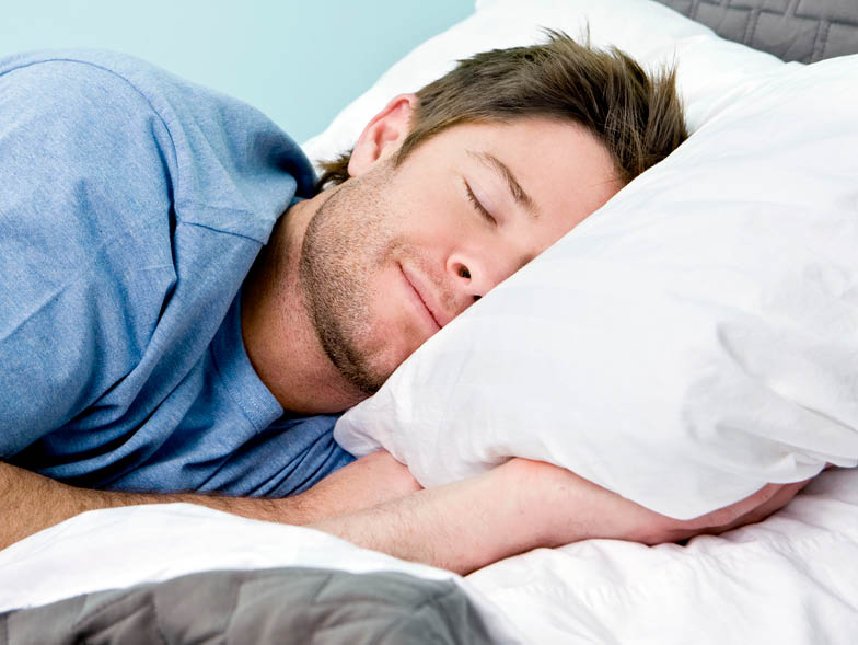 Man sleeping with head on white pillow