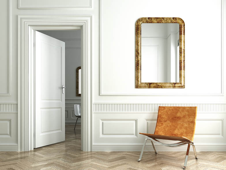 Mirror on white wall with tan chair underneath