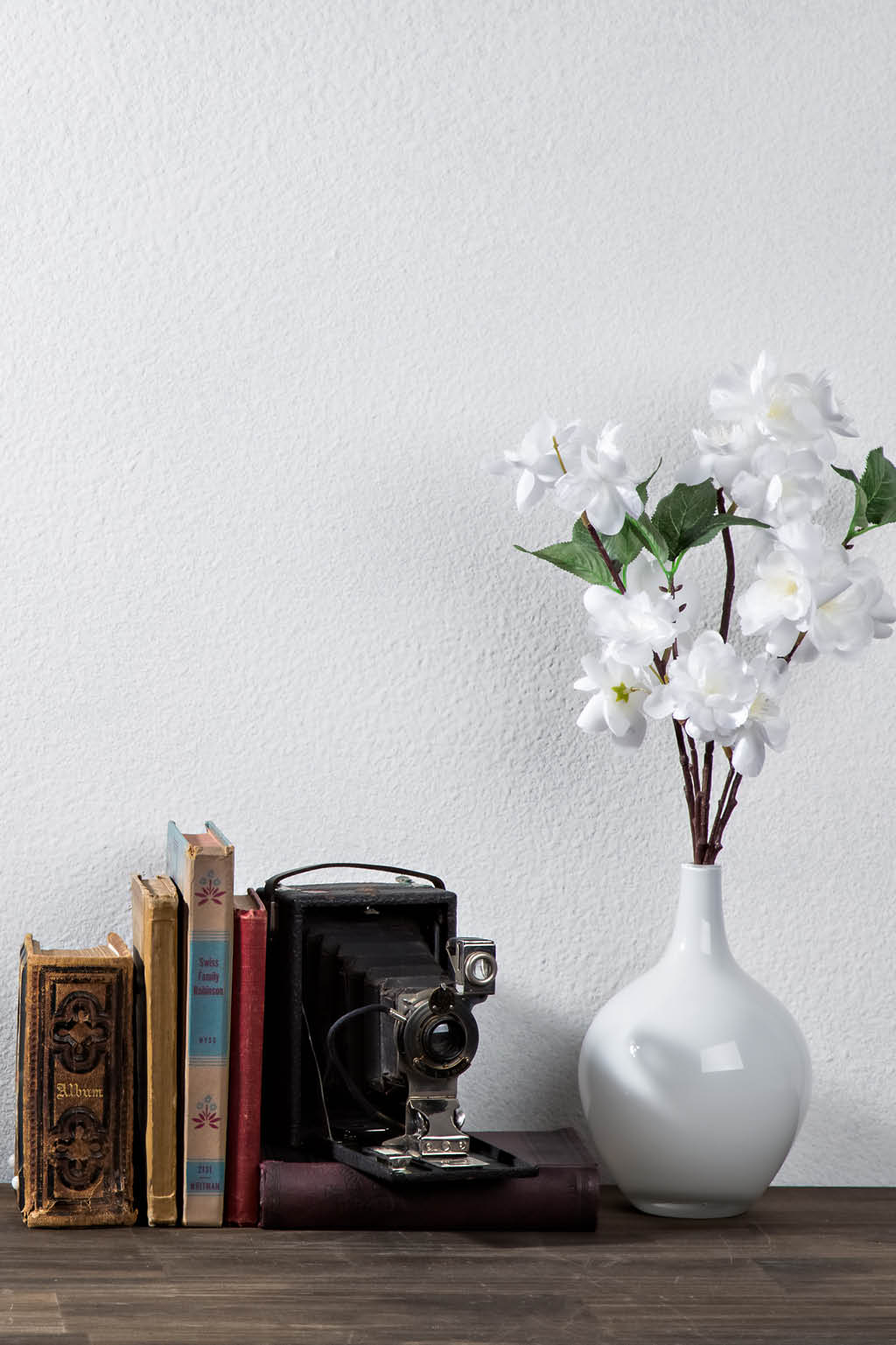 white wall and flowers with books