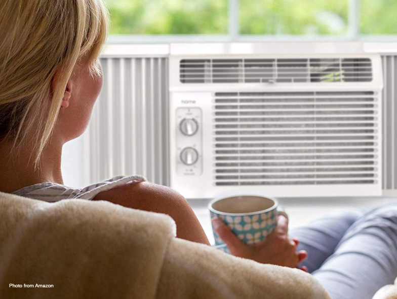 Woman sitting in front of window air conditioning unit
