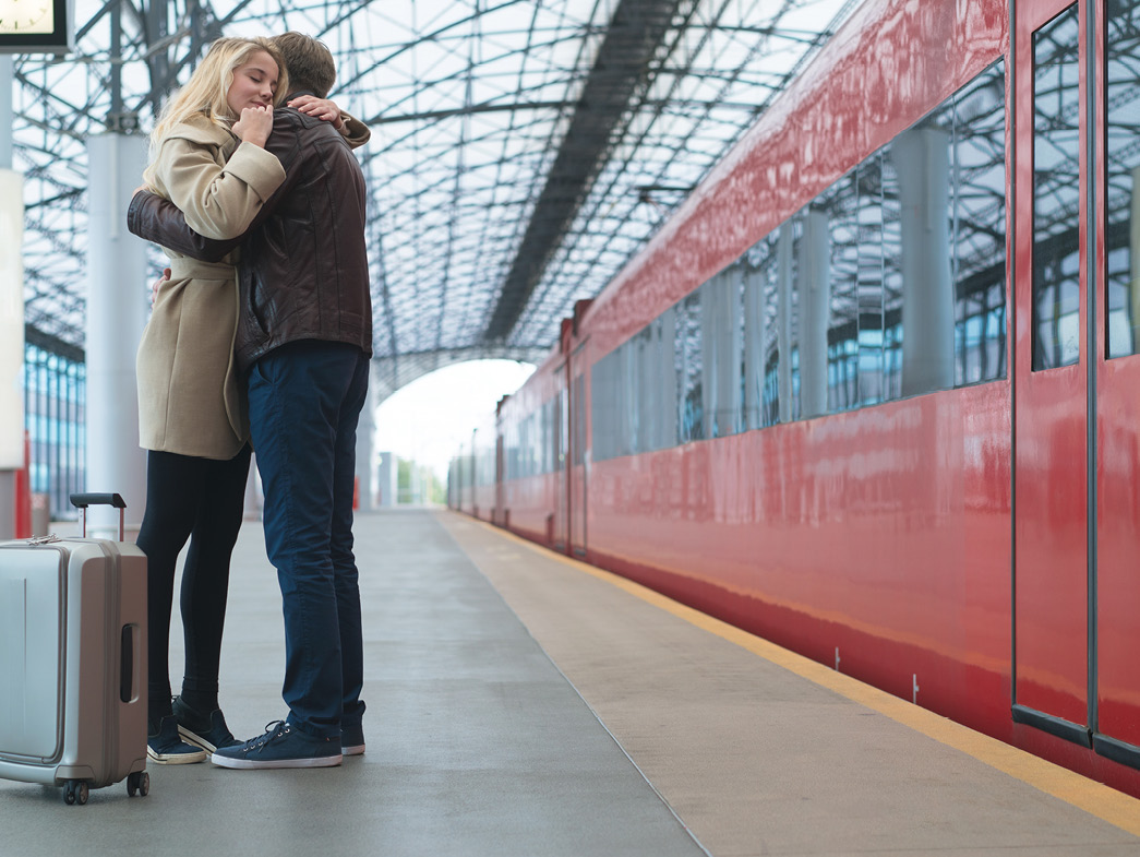 Couple hugging outside of train