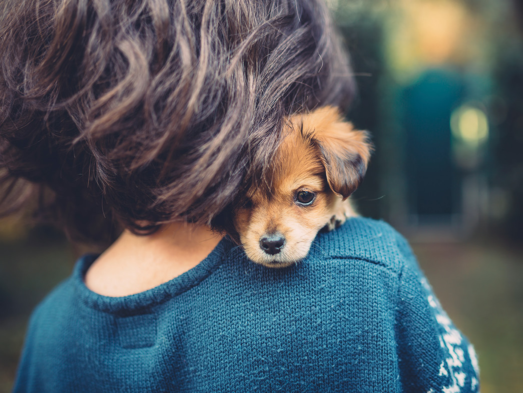 Woman holding puppy on her shoulder