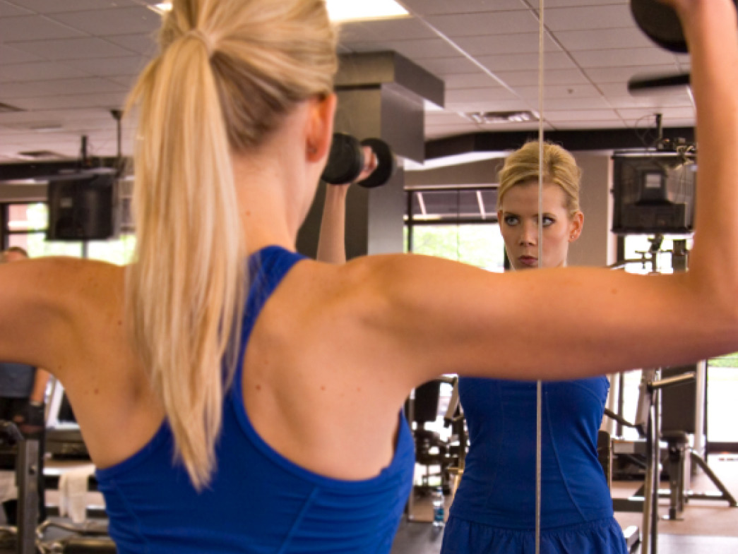 Woman lifting weights in mirror