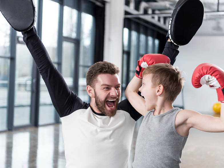 Father and son wearing boxing gloves and cheeering