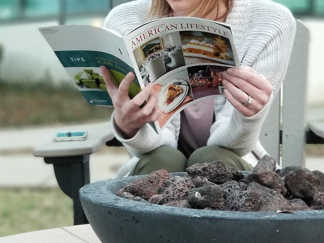 Reading magazine by tabletop firepit