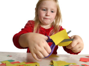 Little girl cutting paper