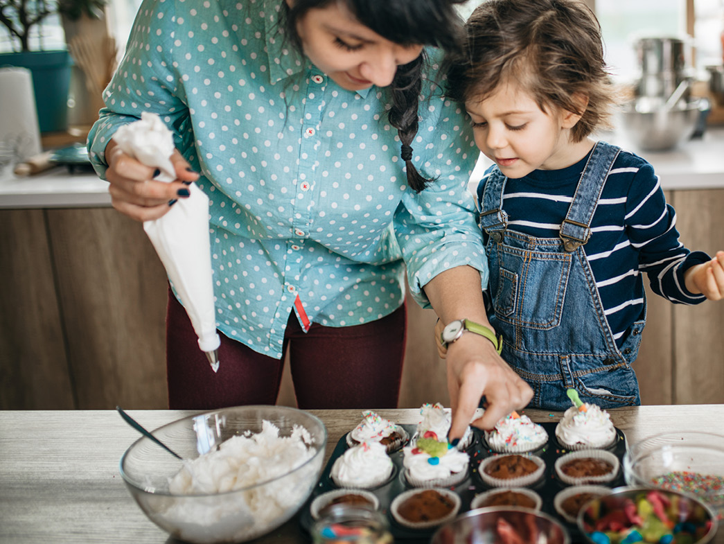 Mother and child decorating cupcakes