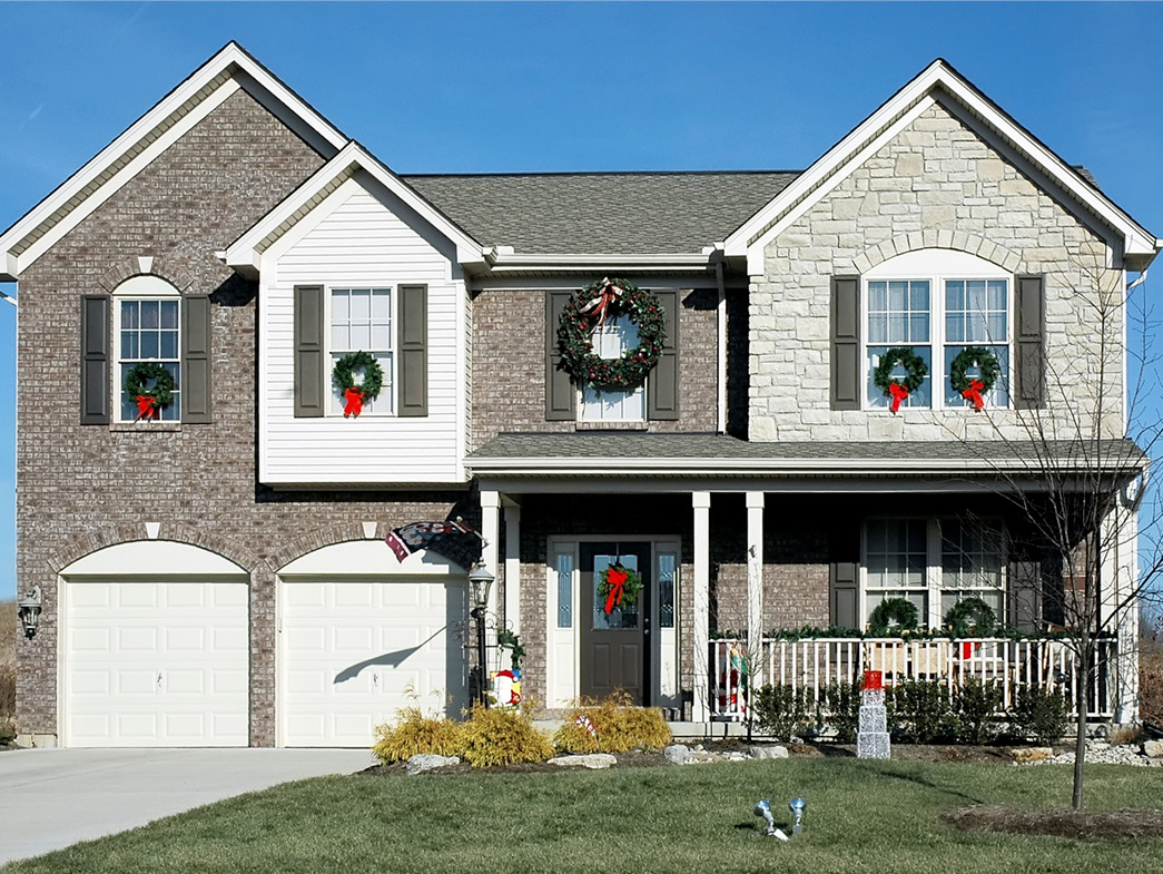 View of home from outside with wreaths in the windows