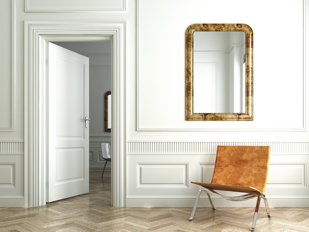 Mirror against white wall with tan chair beneath it