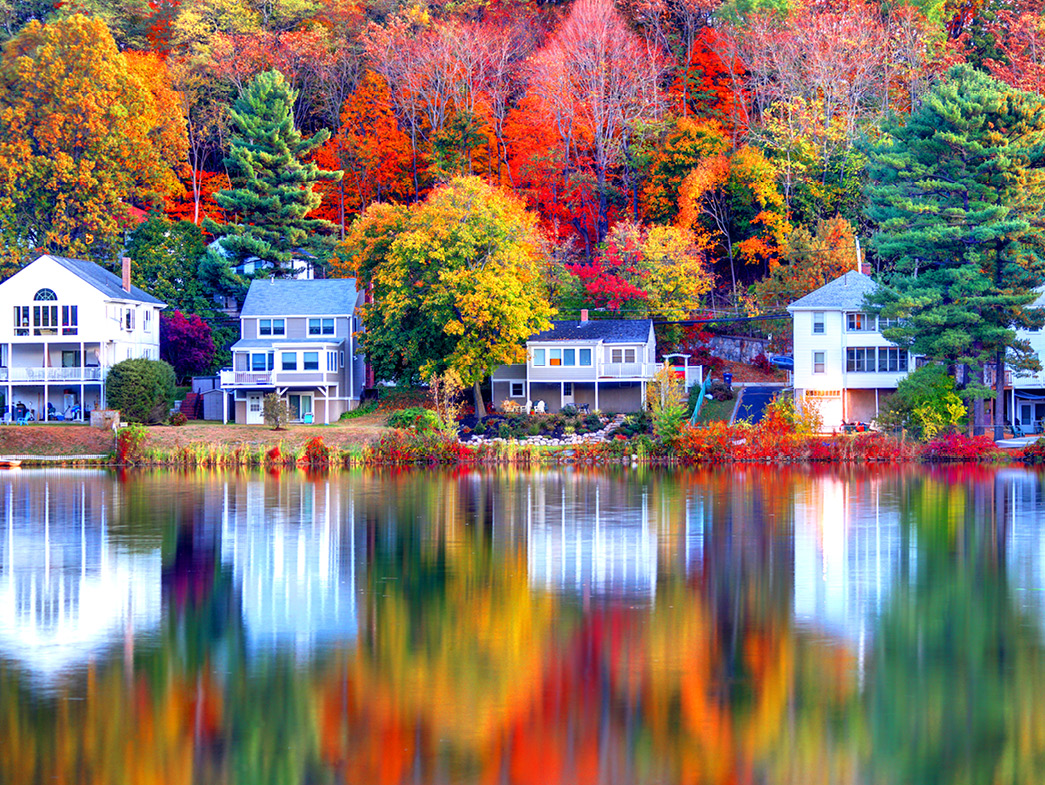 Lakefront houses surrounded by autumn trees