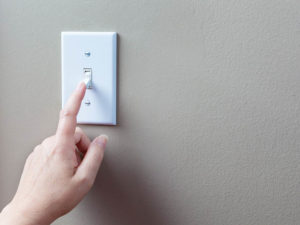 Hand turning off light switch