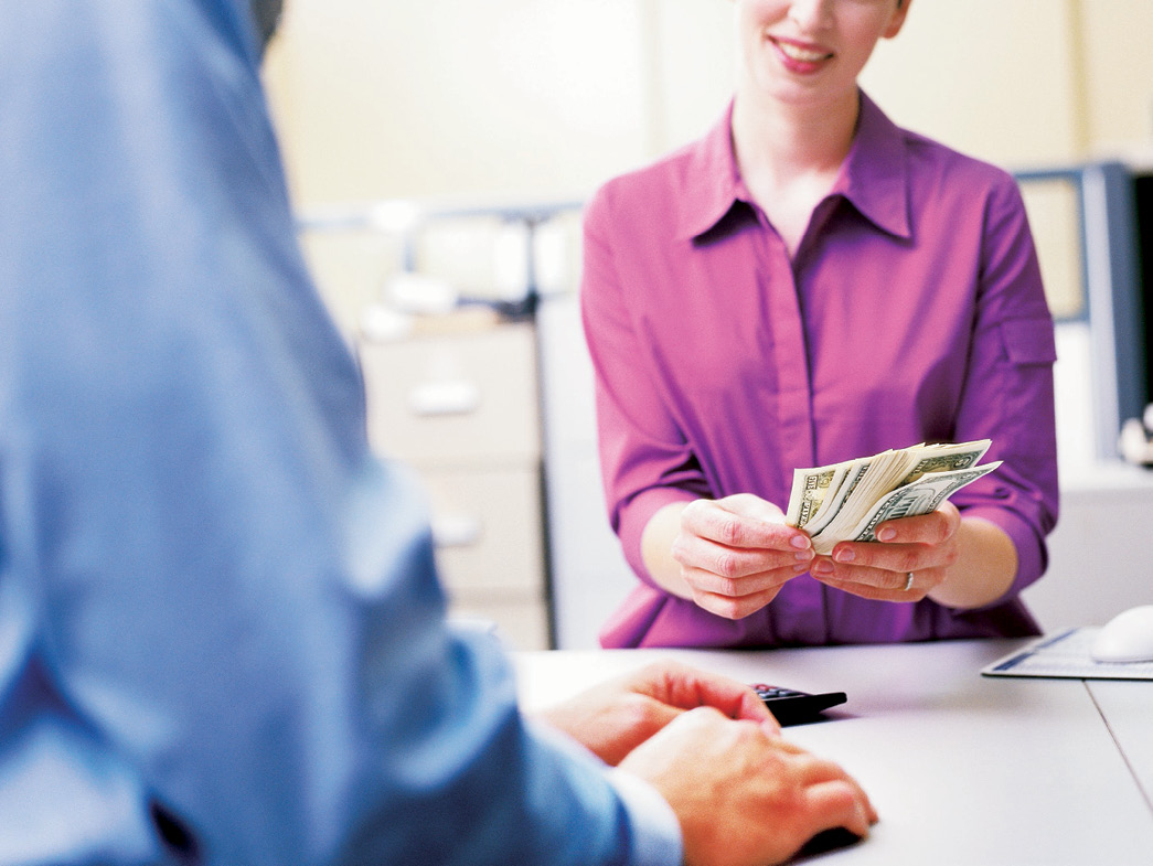 Smiling bank teller counting money