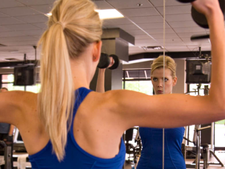 Woman lifting weights in mirror