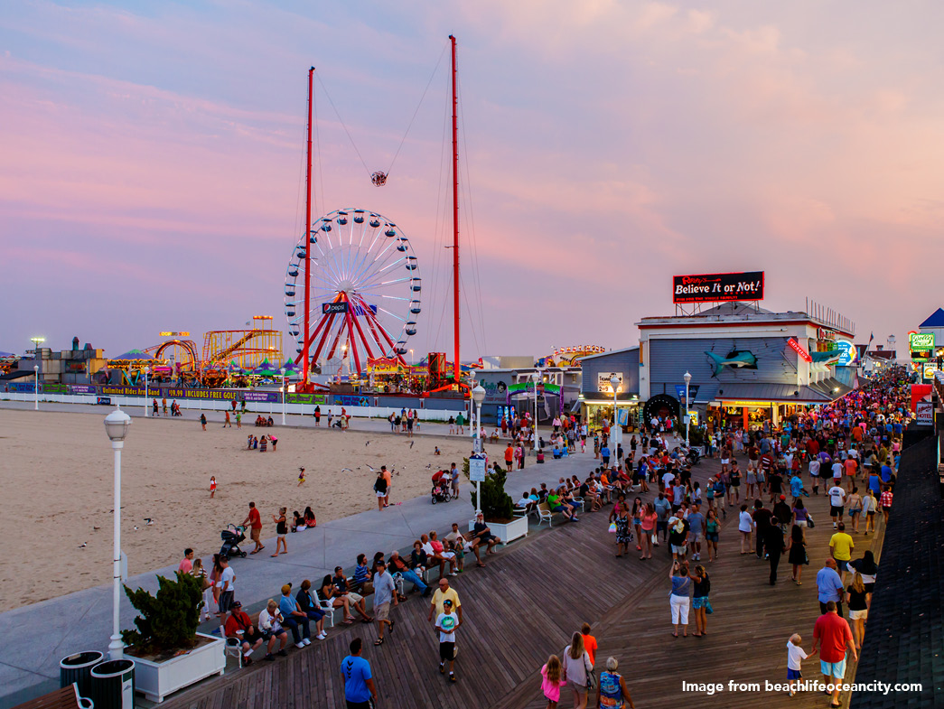 View of boardwalk at sunset with Ferris wheel on pier in background