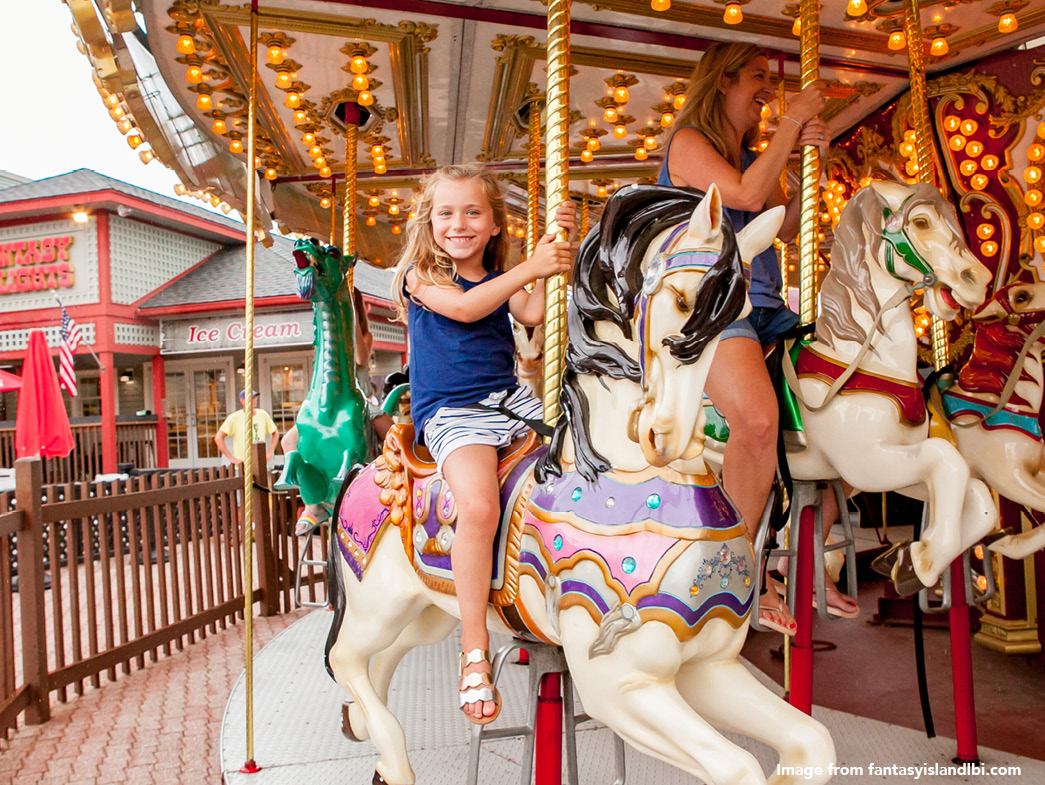 Little girl riding on carousel