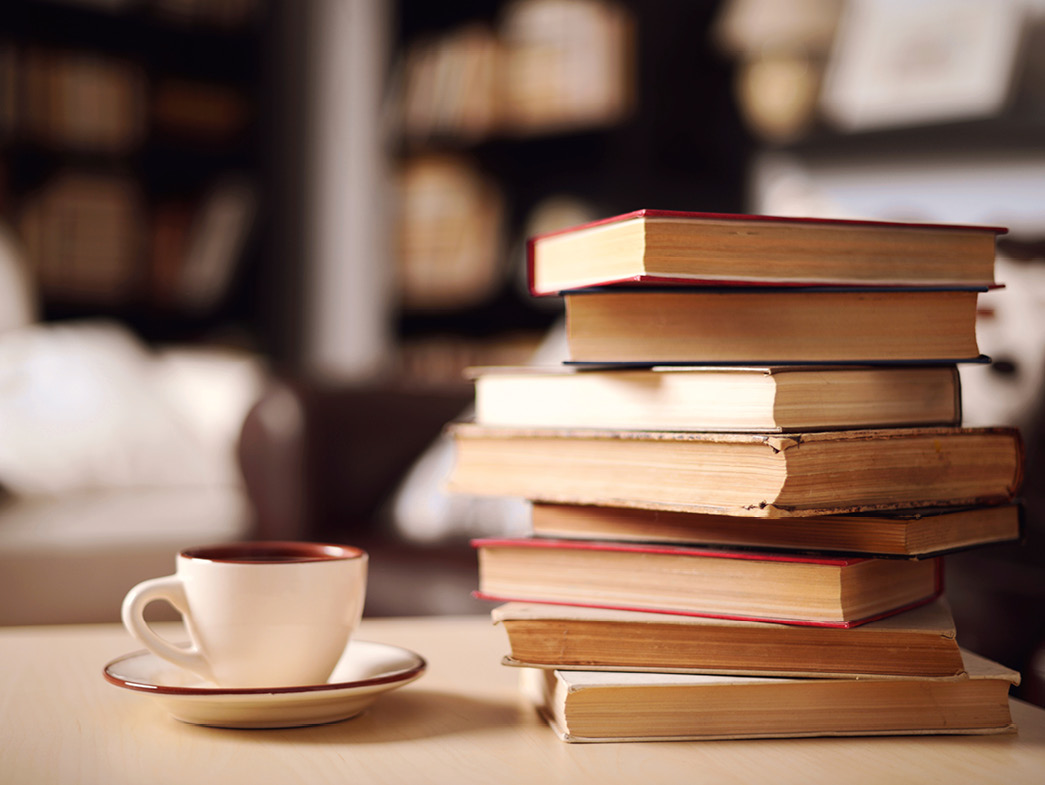 Stack of books beside teacup