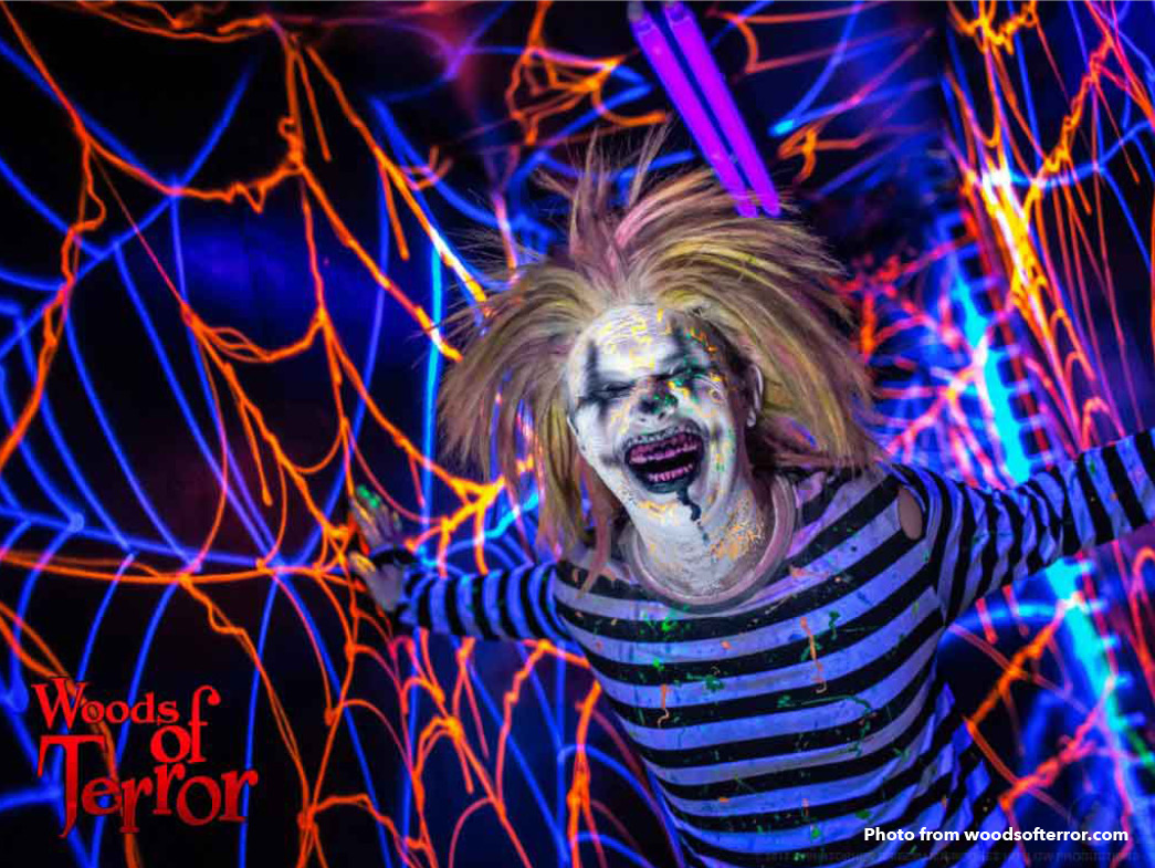 Scary clown in front of blue and purple spiderweb lights