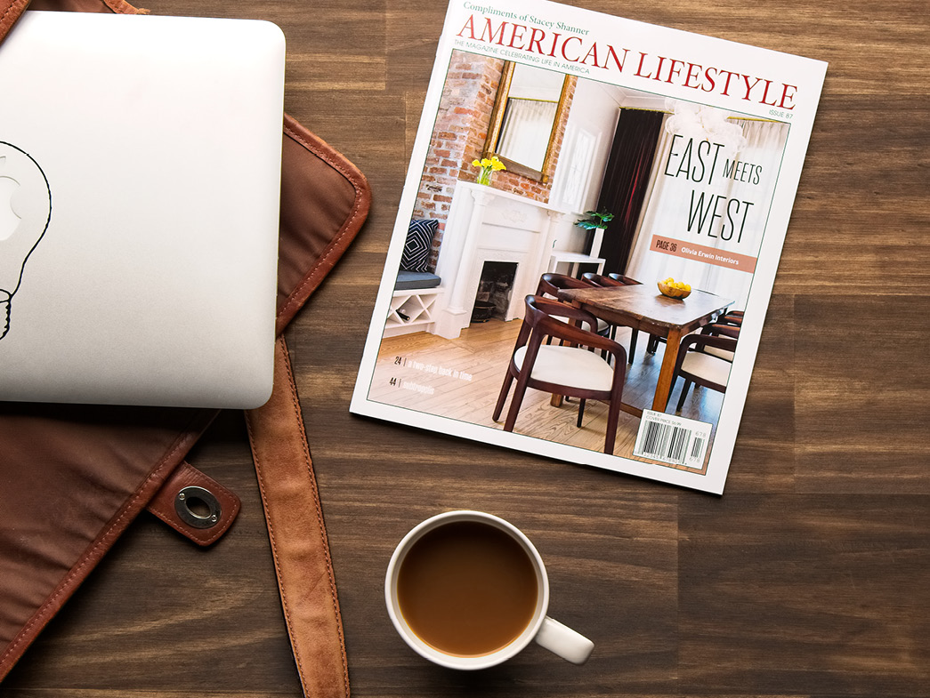 American Lifestyle Magazine sitting on tabletop beside laptop, bag, and cup of coffee