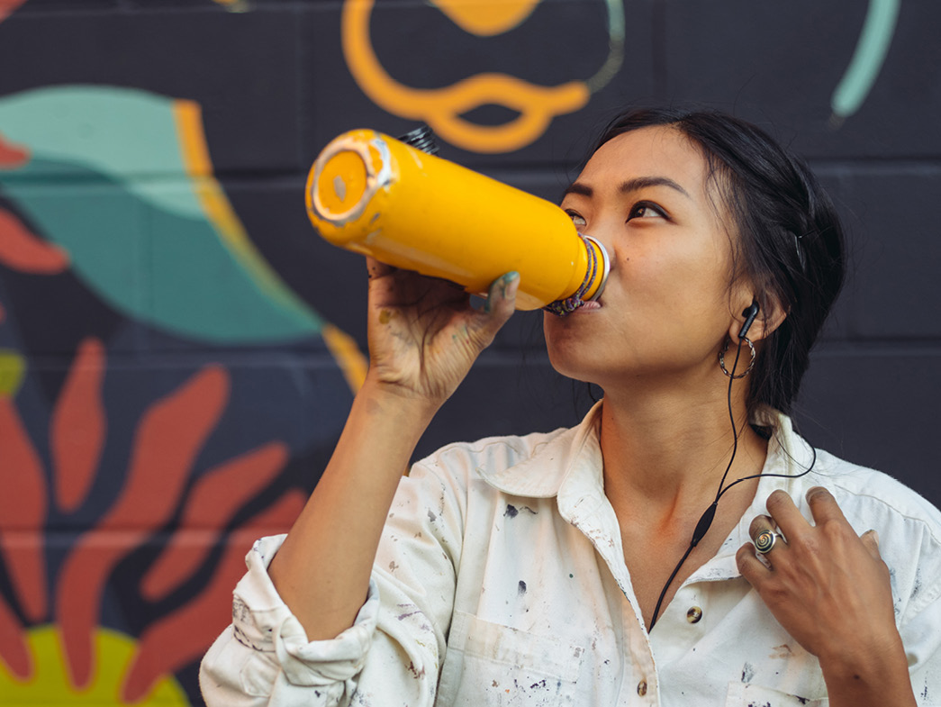 Woman drinking out of refillable water bottle